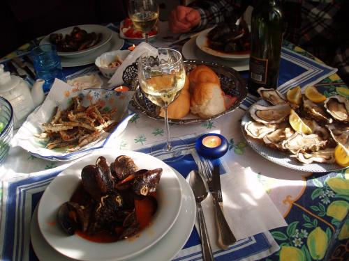 a table with plates of food and a glass of wine at Apartments Butinar Pri Kapitanu in Ankaran