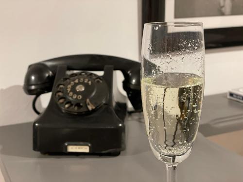 a glass of champagne in front of a phone at Apartament Podcienie z tarasem Bielsko-Biała Old Town in Bielsko-Biala