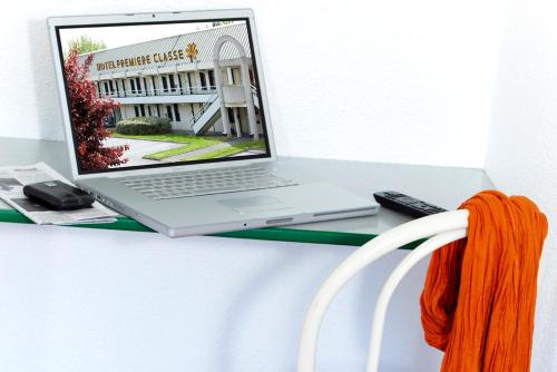 un ordinateur portable installé au-dessus d'un bureau dans l'établissement Premiere Classe Lille Sud - Douai Cuincy, à Cuincy