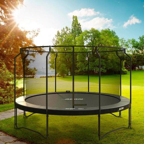 a trampoline in the grass with the sun behind it at Northlands Farm Superior Chalet 2 in Chichester