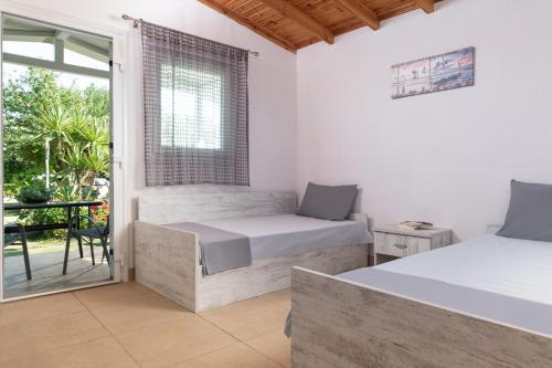 a bedroom with two beds and a balcony at Estell apartments in Sykia Chalkidikis