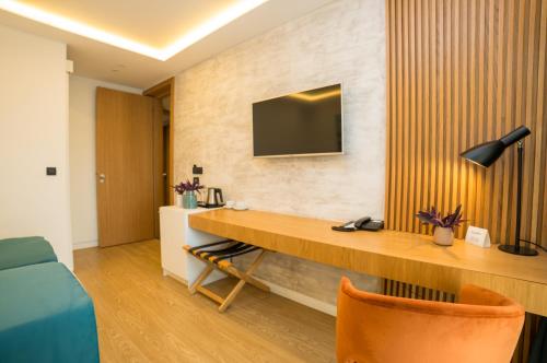 a room with a desk and a tv on a wall at Hotel Admiral in Budva