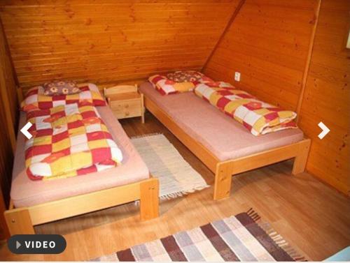 two beds in a small room with at Nabízím chatu na pronájem in Komňa