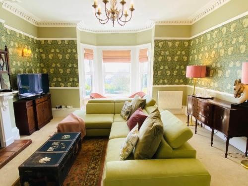 a living room with a couch and a tv at Clarendon View, Historic Apartment with Sea Views in Ventnor