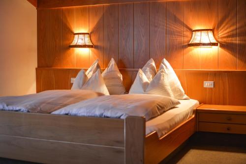 a bedroom with a bed with two lights on it at Appartements Residence Ganthaler in Rablà