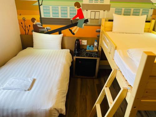 a room with two beds and a woman sitting on a desk at Meci Hotel in Hualien City