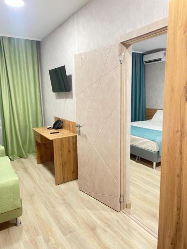 a room with a bedroom with a bed and a desk at Hotel Rubin in Leninogorsk