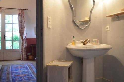 une salle de bain avec un lavabo blanc et une fenêtre dans l'établissement Le Mas Perréal, à Saint-Saturnin-lès-Apt