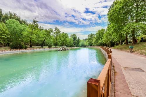 a river in a park with a wooden fence at Suite Acropolis Serres With Parking Next to Center in Serres