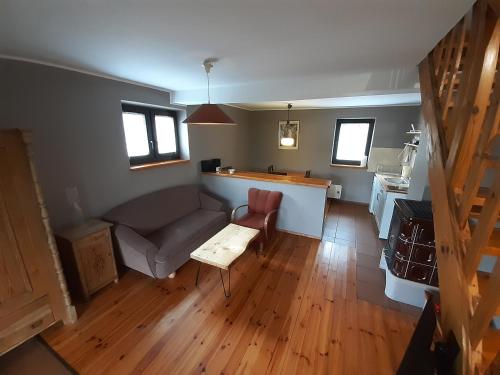 a living room with a couch and a table at Natura Apartamenty in Swaderki