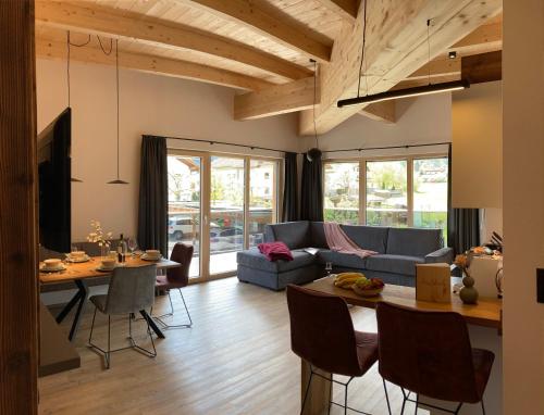salon z niebieską kanapą i stołem w obiekcie Alpen Quartier w mieście Uderns