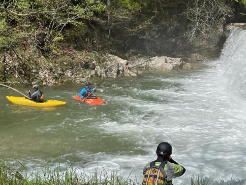 two people in kayaks in a river with a waterfall at Boutique rooms Pri Rogovilcu in Solčava