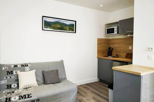 un salon avec un canapé et une cuisine dans l'établissement Exceptionnel : hypercentre Biarritz T2 avec patio, à Biarritz