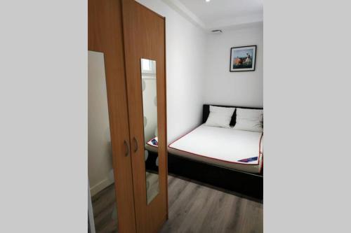 Cette petite chambre comprend un lit et une porte en bois. dans l'établissement Exceptionnel : hypercentre Biarritz T2 avec patio, à Biarritz