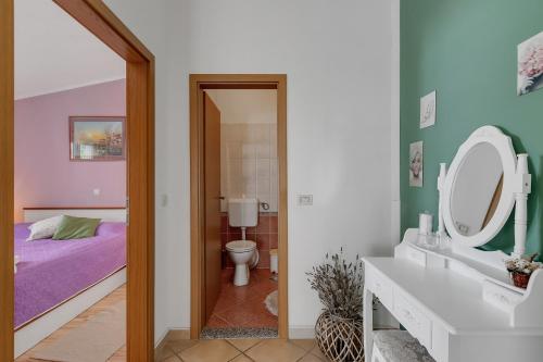 y baño con cama, lavabo y espejo. en Apartmani Luna en Baška Voda