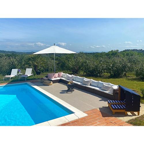 - une piscine avec un canapé et un parasol dans l'établissement Villa Casa Collina Castelfalfi with amazing salt waterpool & AIRCO & VIP service, à Castelfalfi