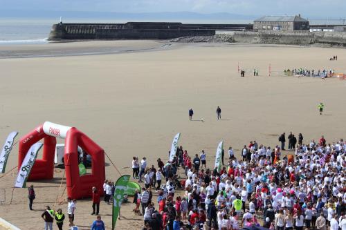 a large crowd of people standing on a beach at Bayside Guest House in Porthcawl