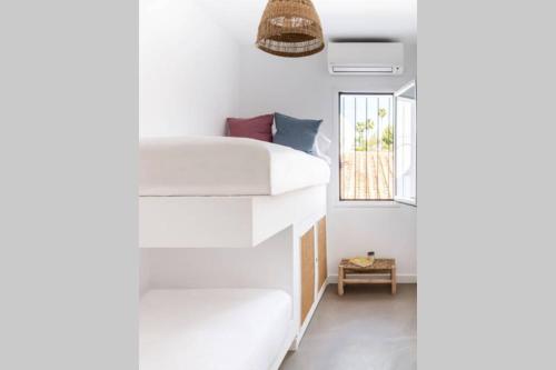 a bedroom with a white bed and a window at Las Flores de Marta (Milla de Oro - Marbella) in Marbella