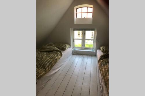 a attic room with two beds and a window at Landlig idyl - direkte til golfbane in Slagelse