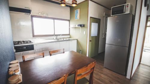 a kitchen with a wooden table and a refrigerator at Furano View House in Furano