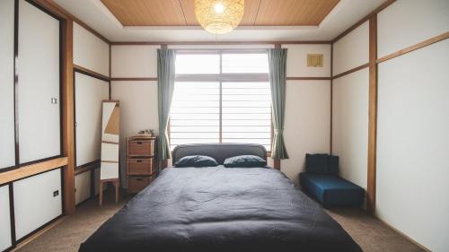 a bedroom with a large bed and a window at Furano View House in Furano