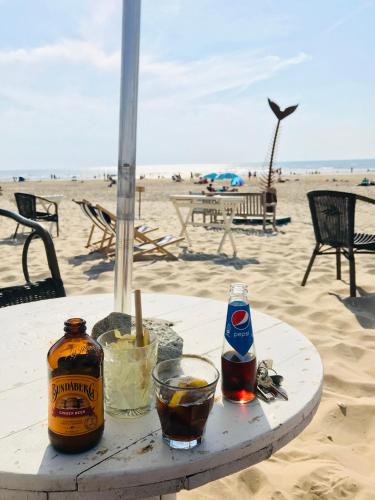 a table on the beach with two drinks on it at Canal House - Homestay in Alkmaar