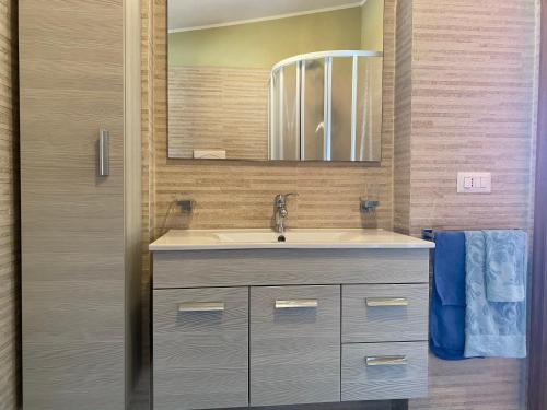 ein Bad mit einem Waschbecken und einem Spiegel in der Unterkunft La Casa Di Rosa in Oliveri