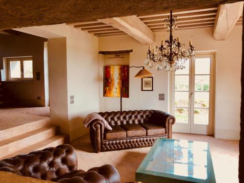 uma sala de estar com um sofá e uma mesa de vidro em Villa La Castellina em Cavriglia