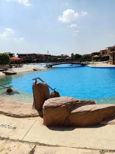 a large swimming pool with blue water at شاليه أرضي بجنينه في مارينا وادي دجله العين السخنه Three Bedroom Chalet with Garden In Marina Wadi Degla Ain El Sokhna - For Families Only in Ain Sokhna