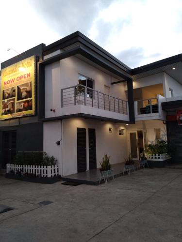 a white building with a balcony and a restaurant at ALESSANDRA HOTEL in Calaca