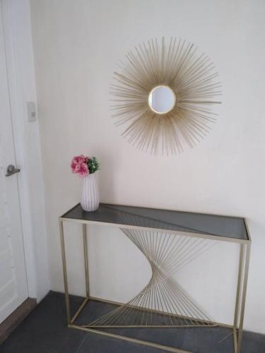 a vase of flowers on a table with a mirror at ALESSANDRA HOTEL in Calaca