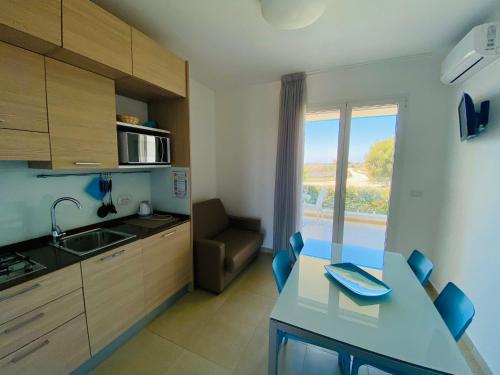 a kitchen with a table and a sink and a couch at Vespucci Apartments Torre Lapillo in Torre Lapillo