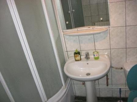 a small bathroom with a sink and a mirror at Lary Hostel in Suceava