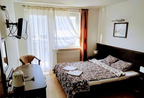 1 dormitorio con cama, mesa y ventana en Willa Latarnik - dokonała lokalizacja, blisko atrakcji, 20min do plaży en Łeba