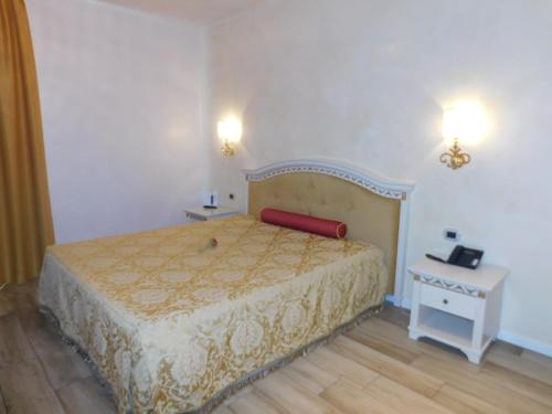 a bedroom with a bed and a table and lights at Palace Hotel & SPA La CONCHIGLIA D' ORO in Vicenza