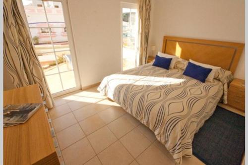 um quarto com uma cama grande e almofadas azuis em Luxury private property-pool, unique sun roof, free wifi em Budens