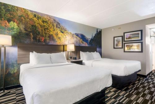 two beds in a hotel room with a painting on the wall at Clarion Pointe Richmond North near University in Richmond