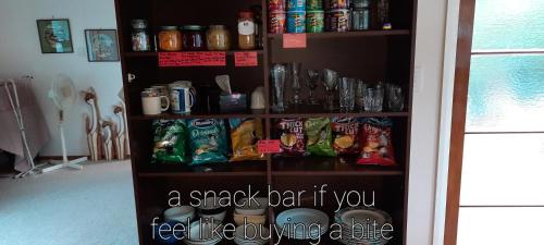 ein Regal voller Getränke und Snacks in einem Zimmer in der Unterkunft The_Cozy_Batch With a rural view in Whanganui