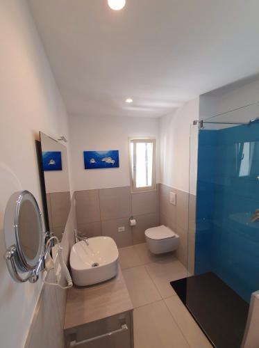 a bathroom with a sink and a toilet and a shower at Appartamento delfino azzurro in Golfo Aranci