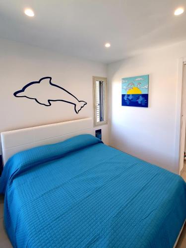 a bedroom with a bed with a dolphin on the wall at Appartamento delfino azzurro in Golfo Aranci