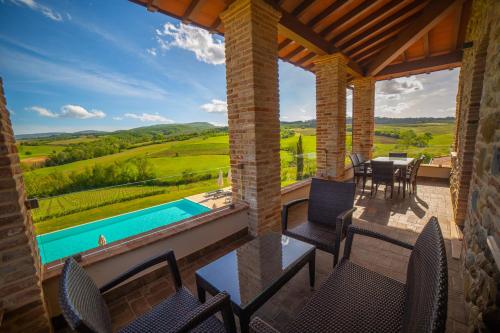 a patio with a table and chairs and a swimming pool at Terra Antica - Resort, Winery & SPA in Montepulciano