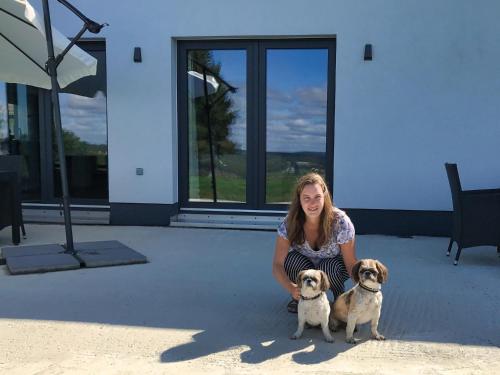 a woman kneeling next to two small dogs at Villa Natica in Butgenbach
