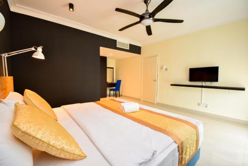 a bedroom with a large bed with a ceiling fan at Tiara Desaru Seaview Residence in Desaru
