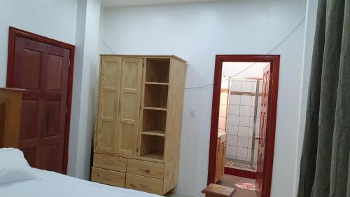 a bedroom with a wooden cabinet and a mirror at Apex boutique apartments in Georgetown
