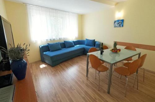 a living room with a blue couch and a table at Apartments Solaris in Sveti Filip i Jakov