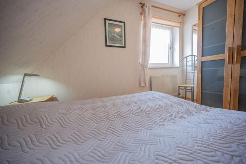 a bedroom with a large white bed with a window at An der Aue 15 Wohnung Ley in Dahme
