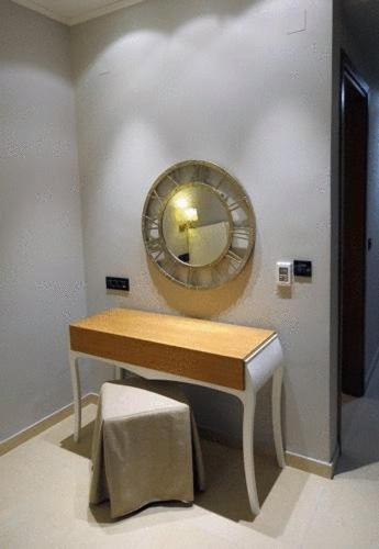 a mirror on a wall next to a wooden table at Hotel Iliana in Filippiada
