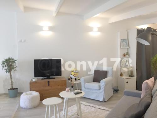 uma sala de estar com um sofá, uma televisão e uma mesa em Studio proche mer et ville TOULON 2 pers em Toulon