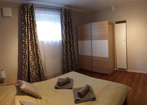 a bedroom with a bed with two napkins on it at Pałac Tatrzański Apartament Tatry in Bukowina Tatrzańska