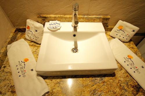 een witte wastafel in een badkamer met 2 handdoeken bij Aparthotel Maracaibo in Puerto Rico de Gran Canaria